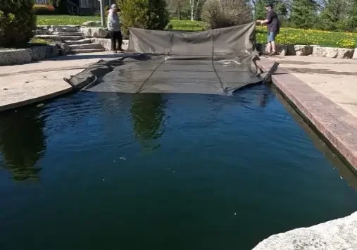 People covering pool with a safety net.