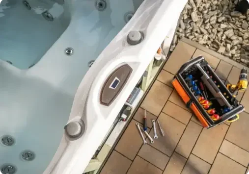 Hot tub with tools on patio floor.